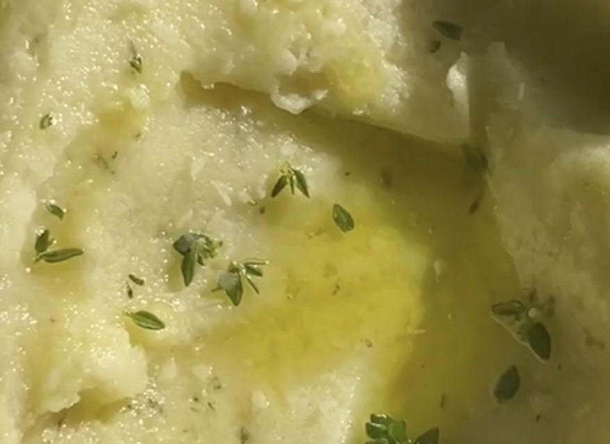 A closeup of potatoes with olive oil and thyme on top