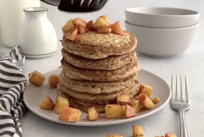 A large stack of pancakes at a table setting