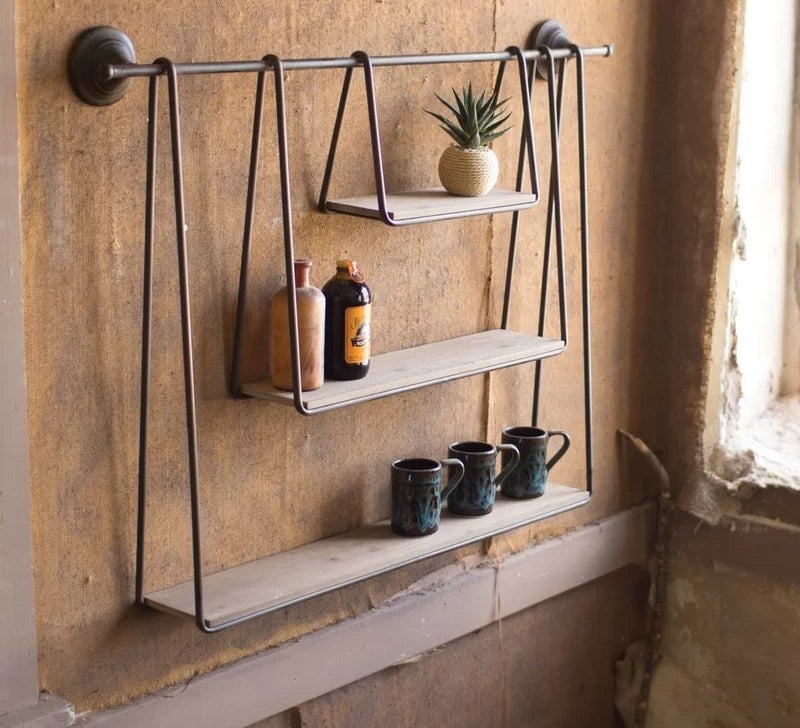 Three shelves hanging from a towel rod