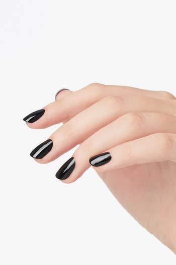 Model wearing OPI black nail polish on fingers