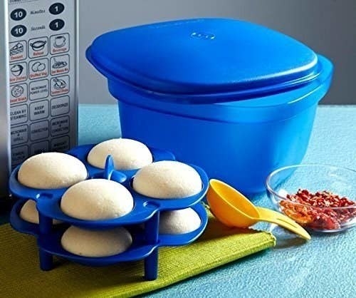 The multipurpose cooking took pictured with a measuring spoon and idli maker.