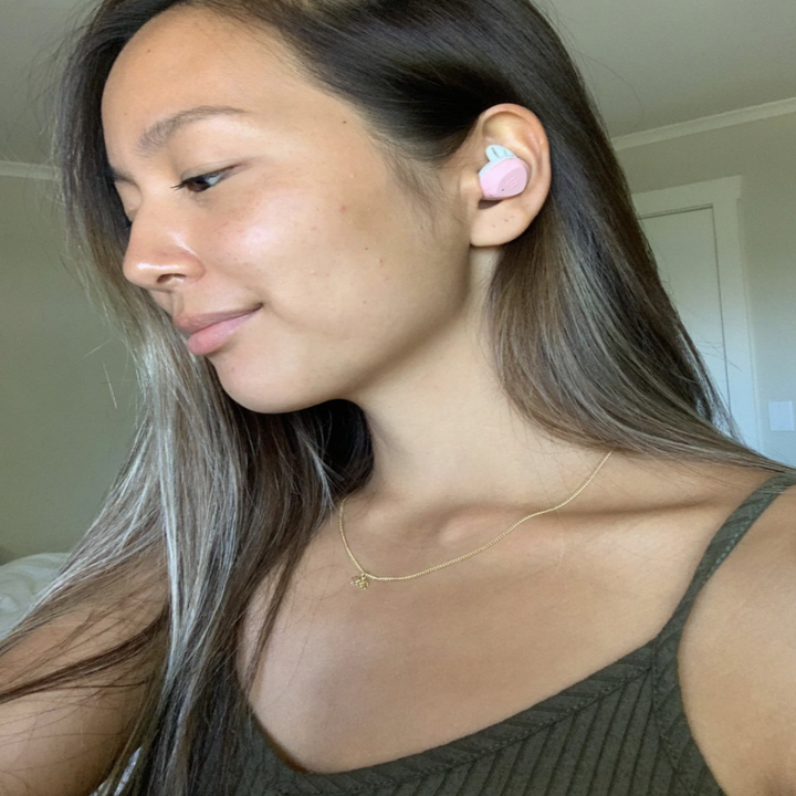 A reviewer wearing the earbuds