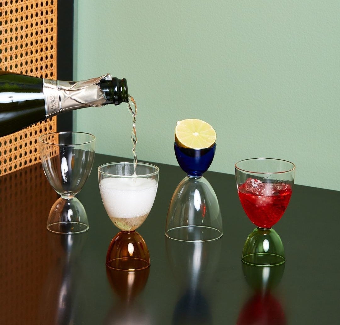 Colorful hourglass cocktail glasses lined up 