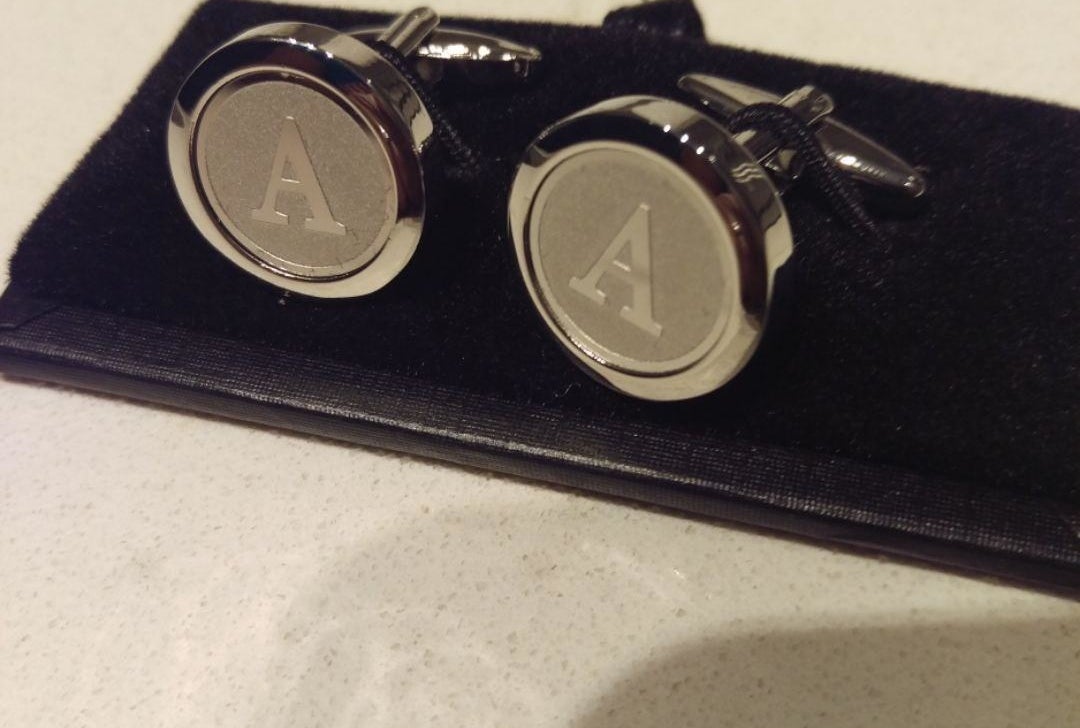 A reviewer&#x27;s pair of the silver tone cufflinks in the letter A, with a rounded shape, outside lip around the engraving