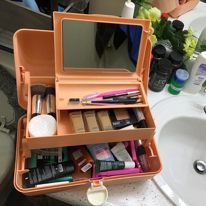 The orange caboodle open to show the compartments