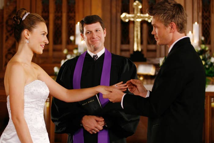 a woman holding the hand of a man at the altar, getting married