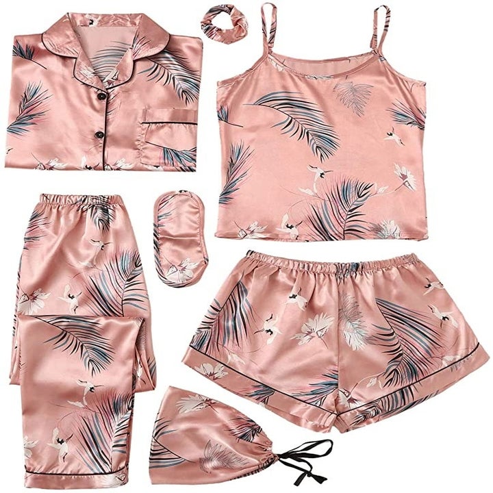 the satin pajama set in pink with a leaf print all over it