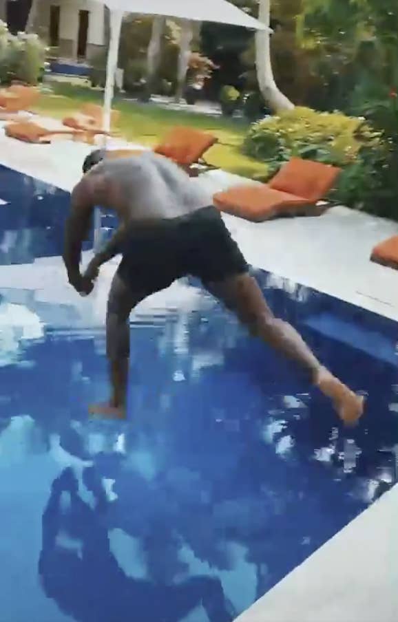 Diddy jumping into a pool feet-first with diving hands