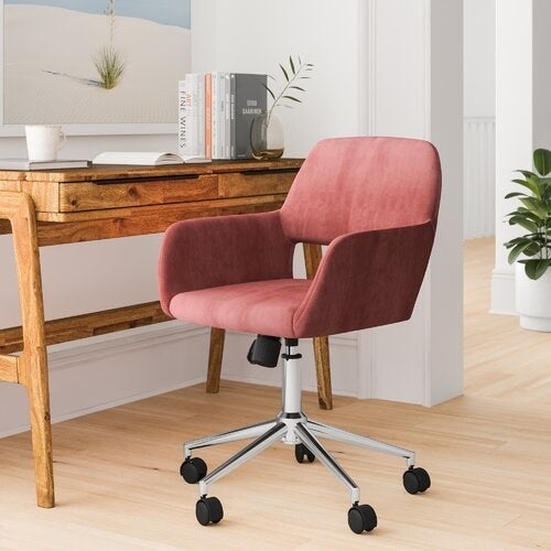 rose colored desk chair with chrome legs and wheels