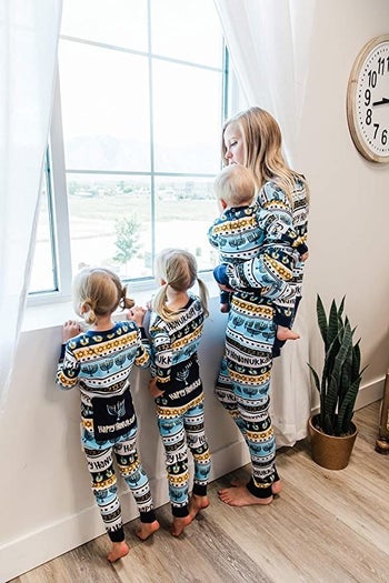 a family wearing matching hanukkah onesies