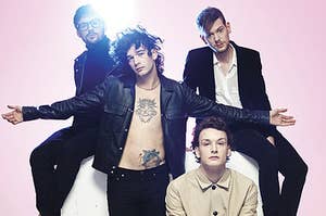 The 1975 band members in front of a pink background 