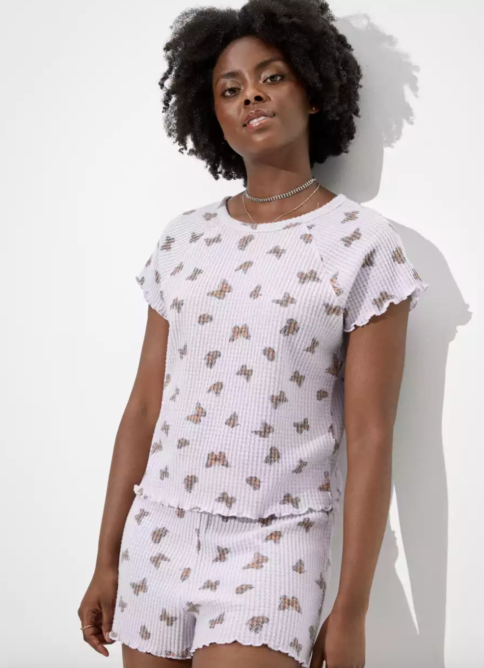 a model in waffle knit tee and shirts with a butterfly print on it