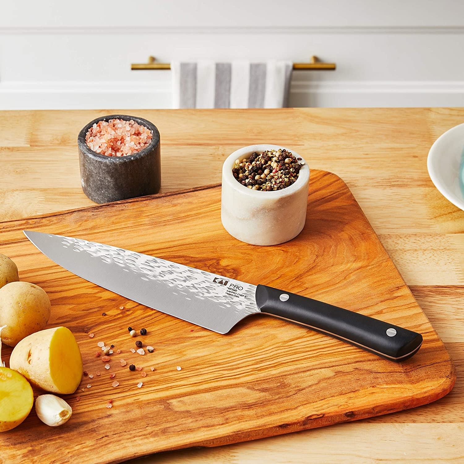 Japanese chef&#x27;s knife resting on cutting board 