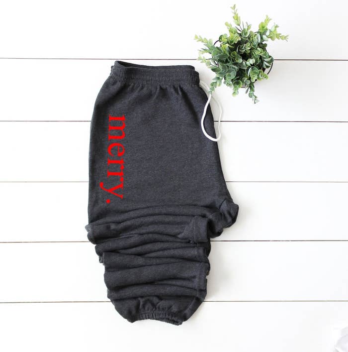 gray sweatpants with "merry" written on them in red
