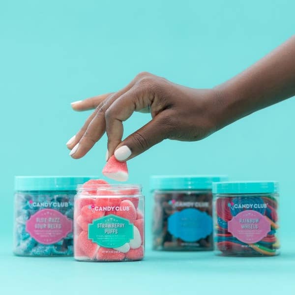four jars of candy (rainbow wheels, strawberry puffs, blue raspberry sour tape, and something chocolate)