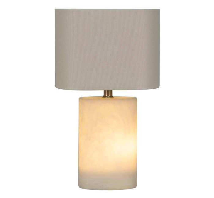 The lamp, which has a shade and base both in off-white, and the base also illuminates