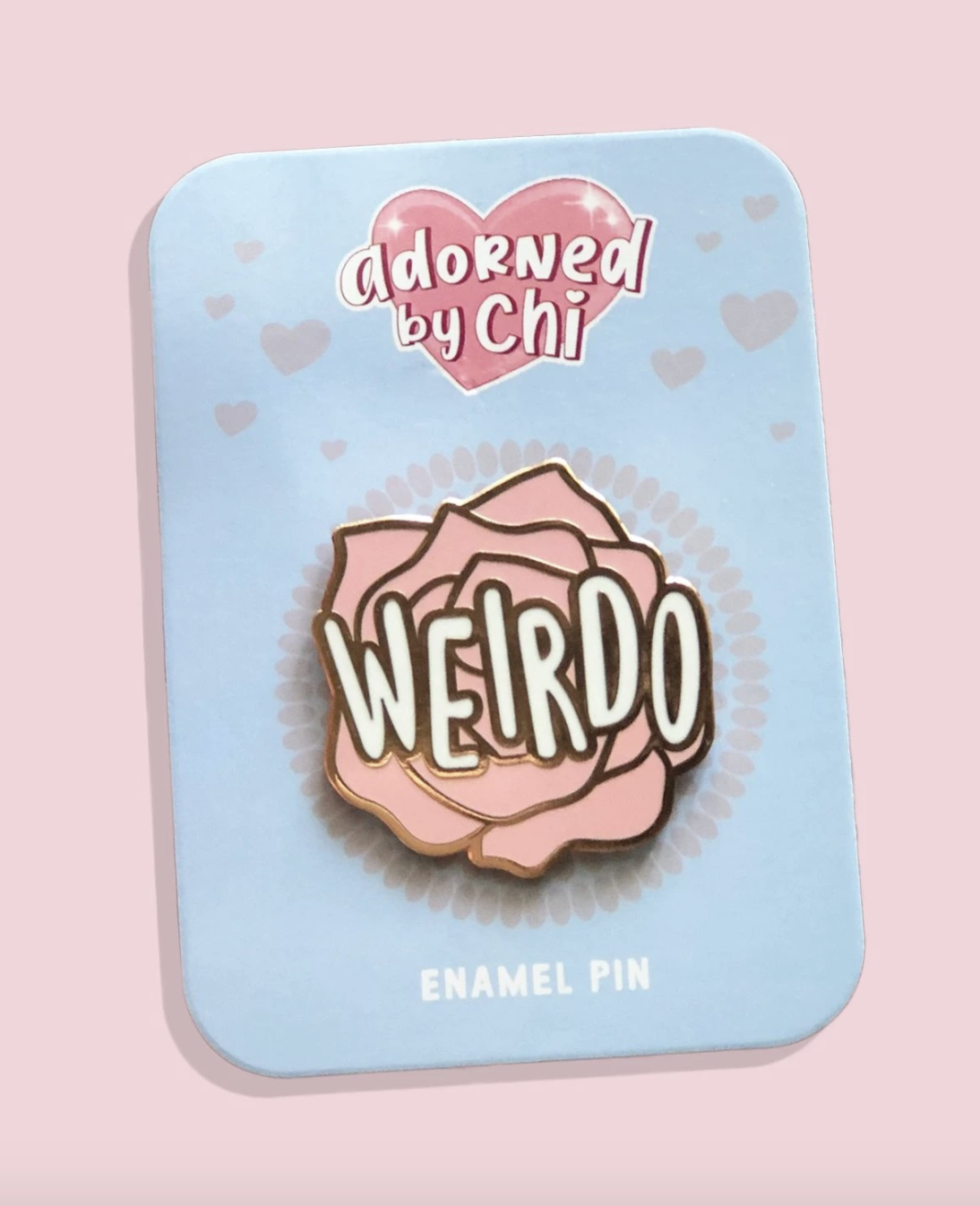 pin has pink flower with the word &quot;weirdo&quot; on it in white letters and gold outline 