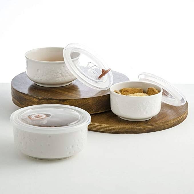 White ceramic serving bowls with plastic lids.