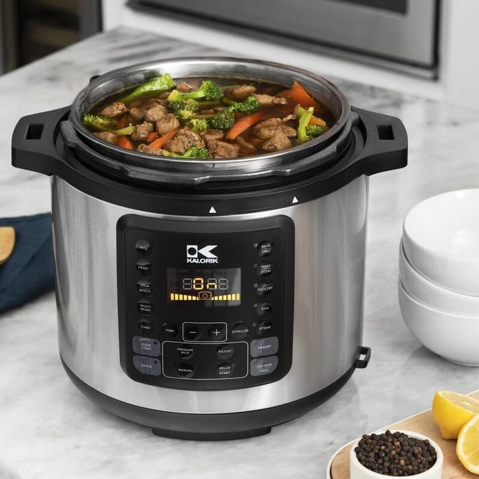 a silver and black pressure cooker holding stew on a counter