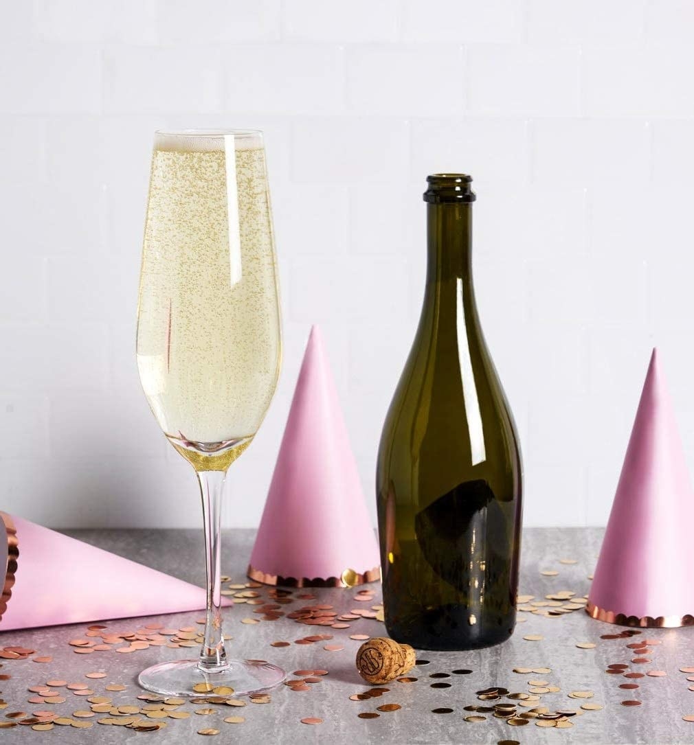 A bottle of prosecco beside a glass holding the entire bottle
