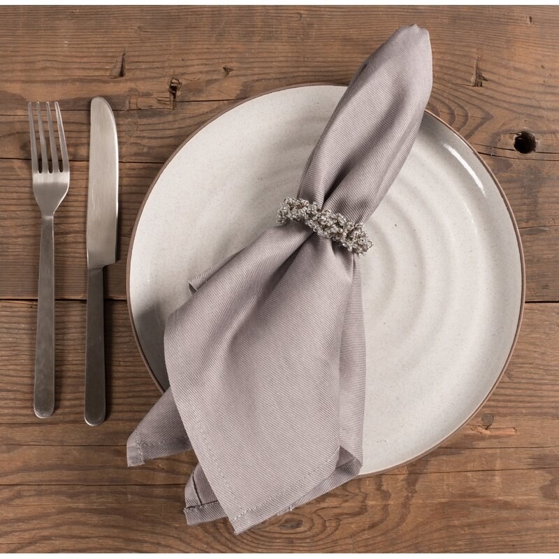 a taupe cloth napkin on a plate setting