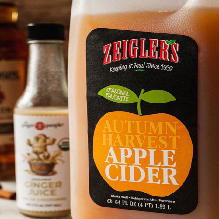 A container of apple cider and ginger juice.