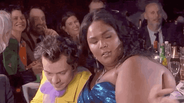 Harry Styles and Lizzo hugging at an award&#x27;s table