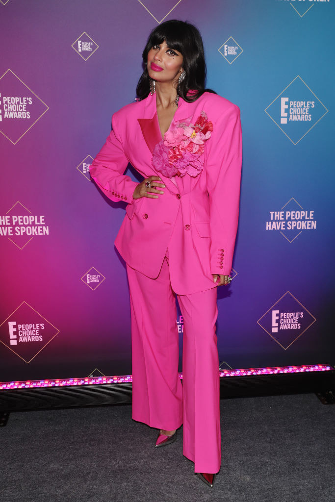 Jameela Jamil wears an oversized yet structured blazer with flowers on the lapel and matching pants