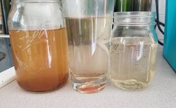 Three glass containers showing the progression of colored water to come out of machine. From brown water on the left to clean clear water on the right.