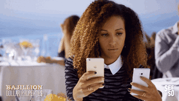 GIF of a woman looking at two smartphones
