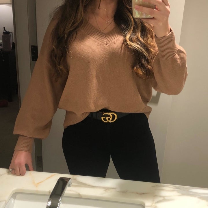 A reviewer wearing the sweater in tan