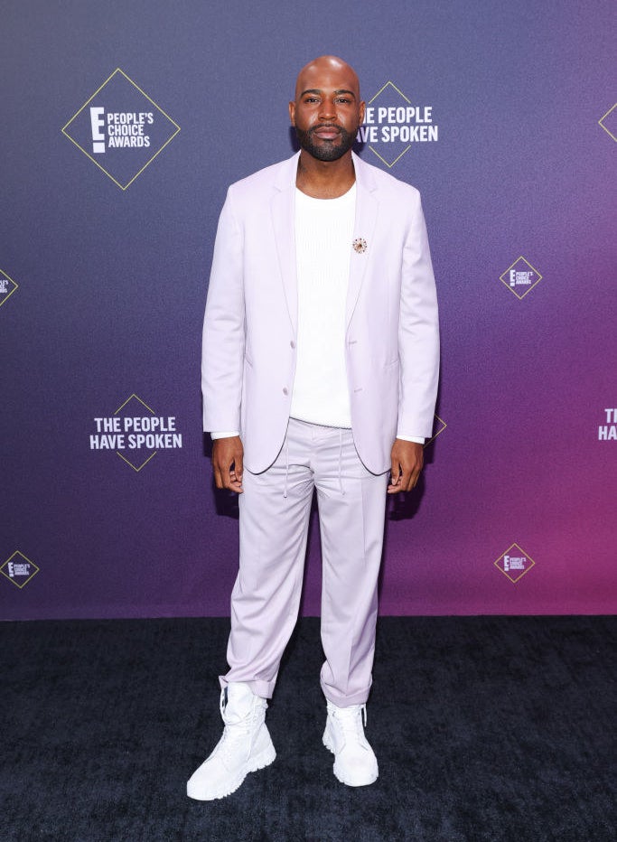 Karamo Brown wears a pastel-colored blazer with matching pants and high-top sneakers