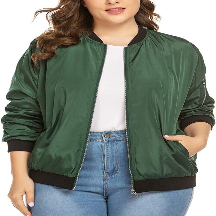 A model wearing the zip-up jacket in green with black trim