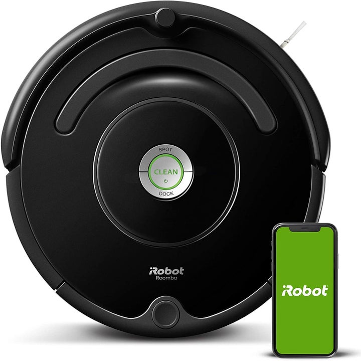 The Roomba with a smartphone open to the iRobot app