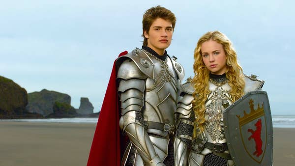 Will Wagner (Gregg Sulkin) and Allie Pennington (Britt Robertson) stand in knight armor on the beach.
