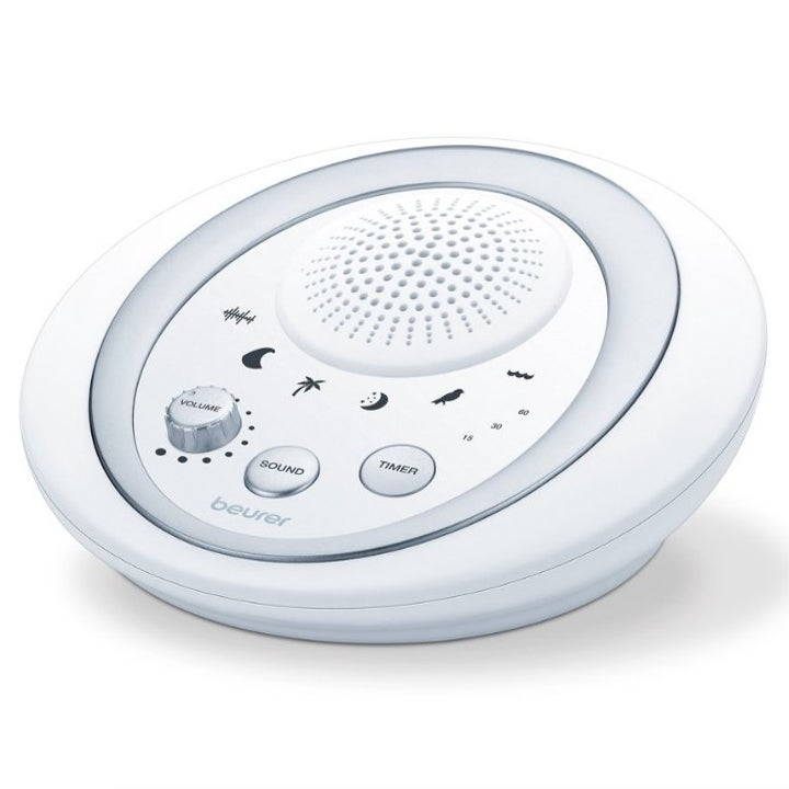 Round white noise machine with small speaker, volume control, and two buttons