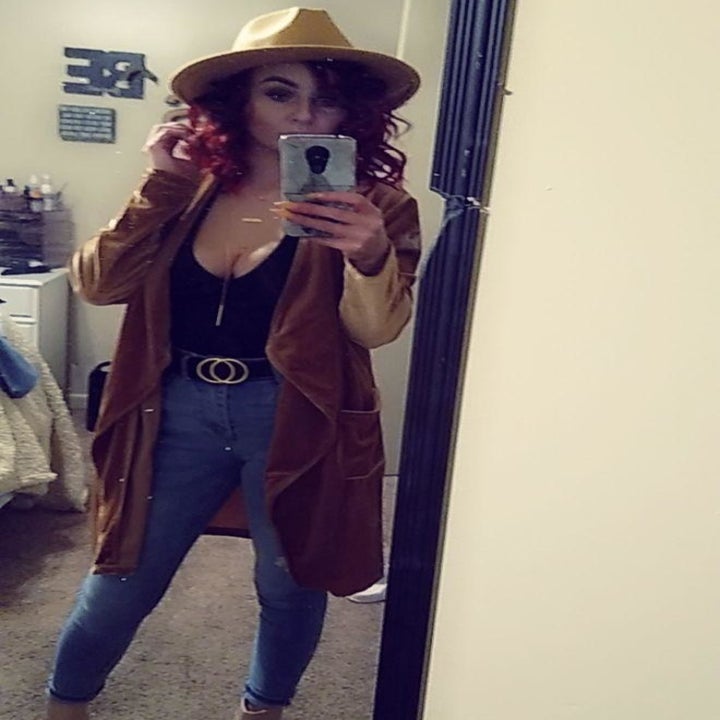 A reviewer wearing the jacket in light brown. It hits around the knee