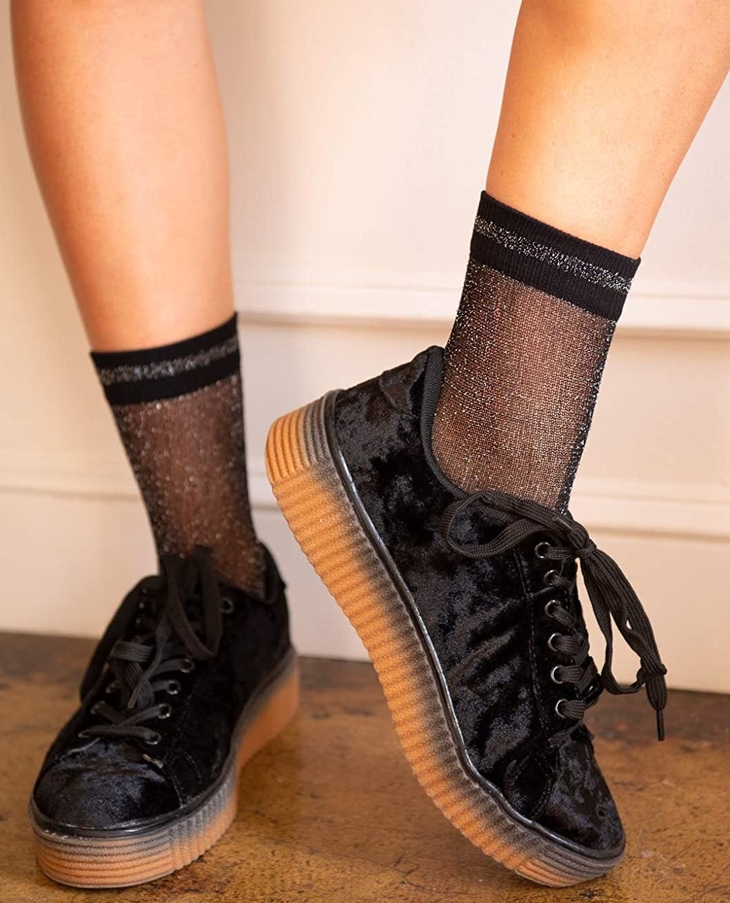 model wearing the black glittery socks with black sneakers 