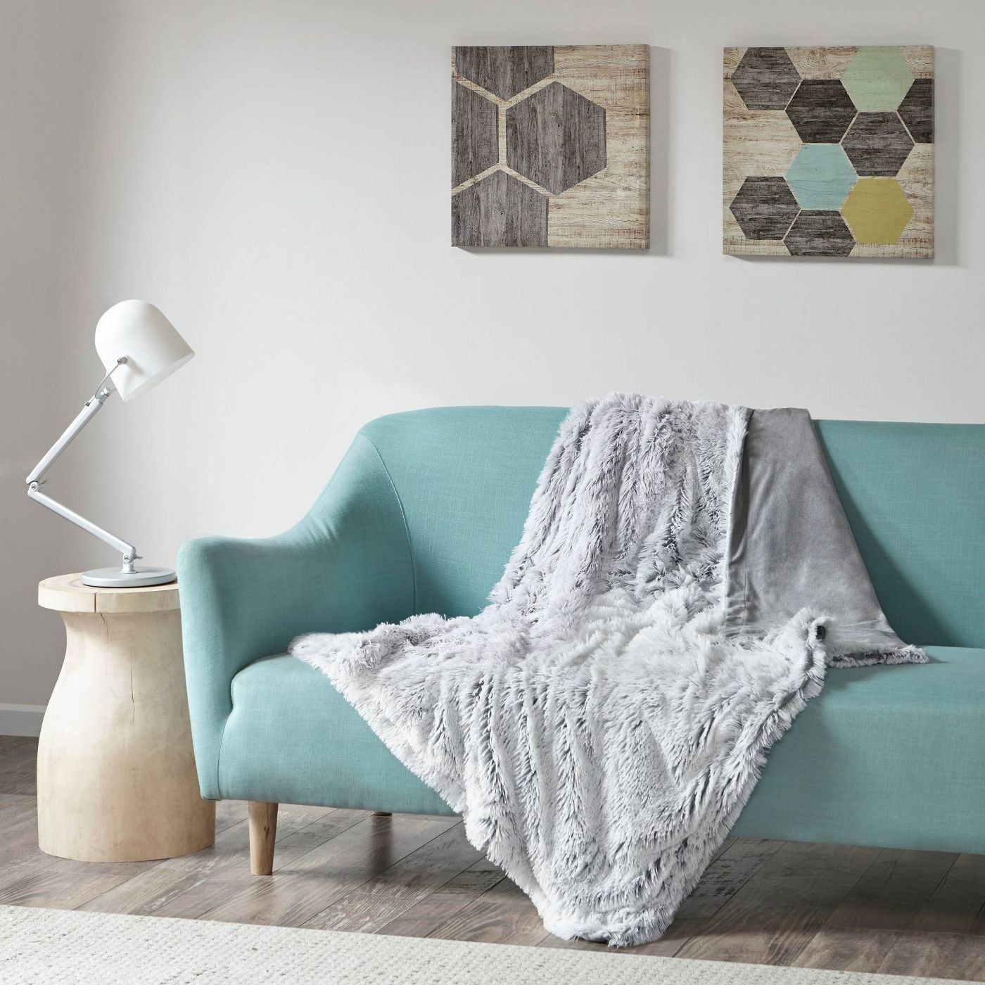 The faux fur throw in gray draped over a couch