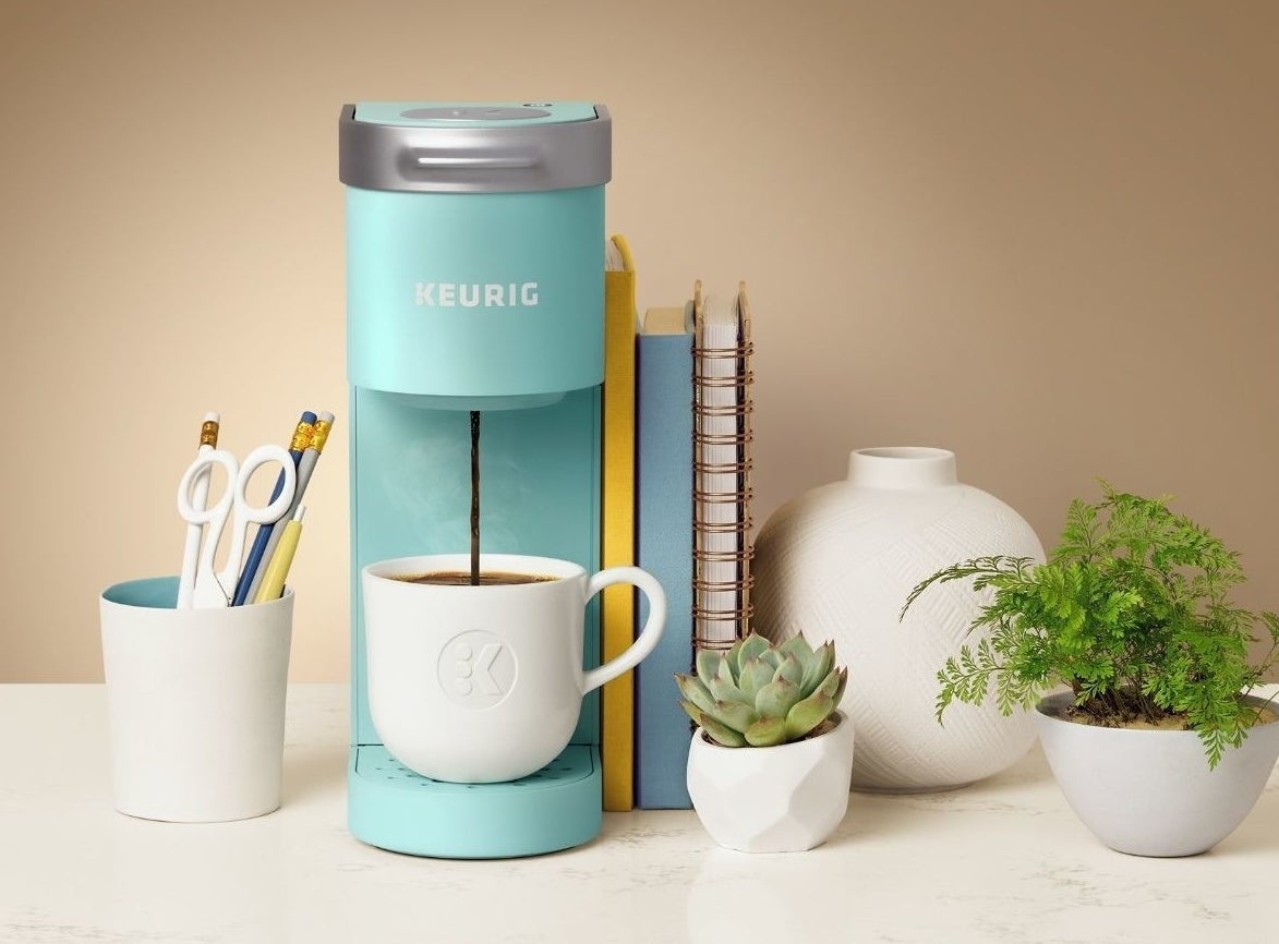 The Keurig K-Mini in blue brewing a cup of coffee
