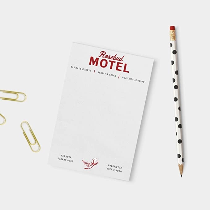The notepad, with the Rosebud Motel log at the top and subheading &quot;Elmdale County Schitt&#x27;s Creek roadside lodging.&quot; At the bottom it reads &quot;Manager Johnny Rose, Proprietor Stevie Budd&quot;