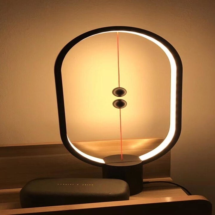 A reviewer photo of the illuminated lamp on a small table 