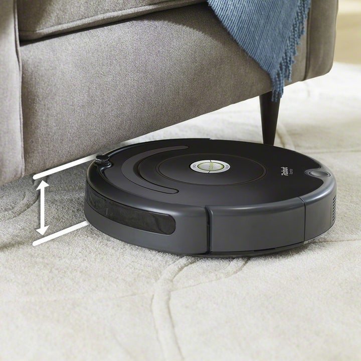 An iRobot Roomba Robot Vaccum maneuvering under a chair 