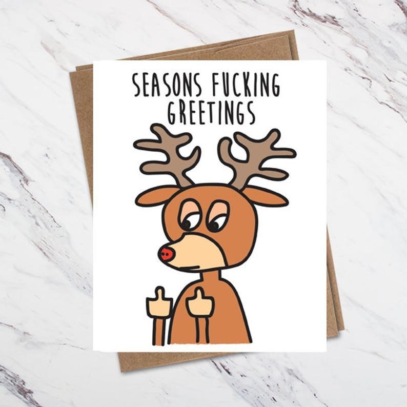 A card with a reindeer with two middle fingers up saying seasons fucking greetings