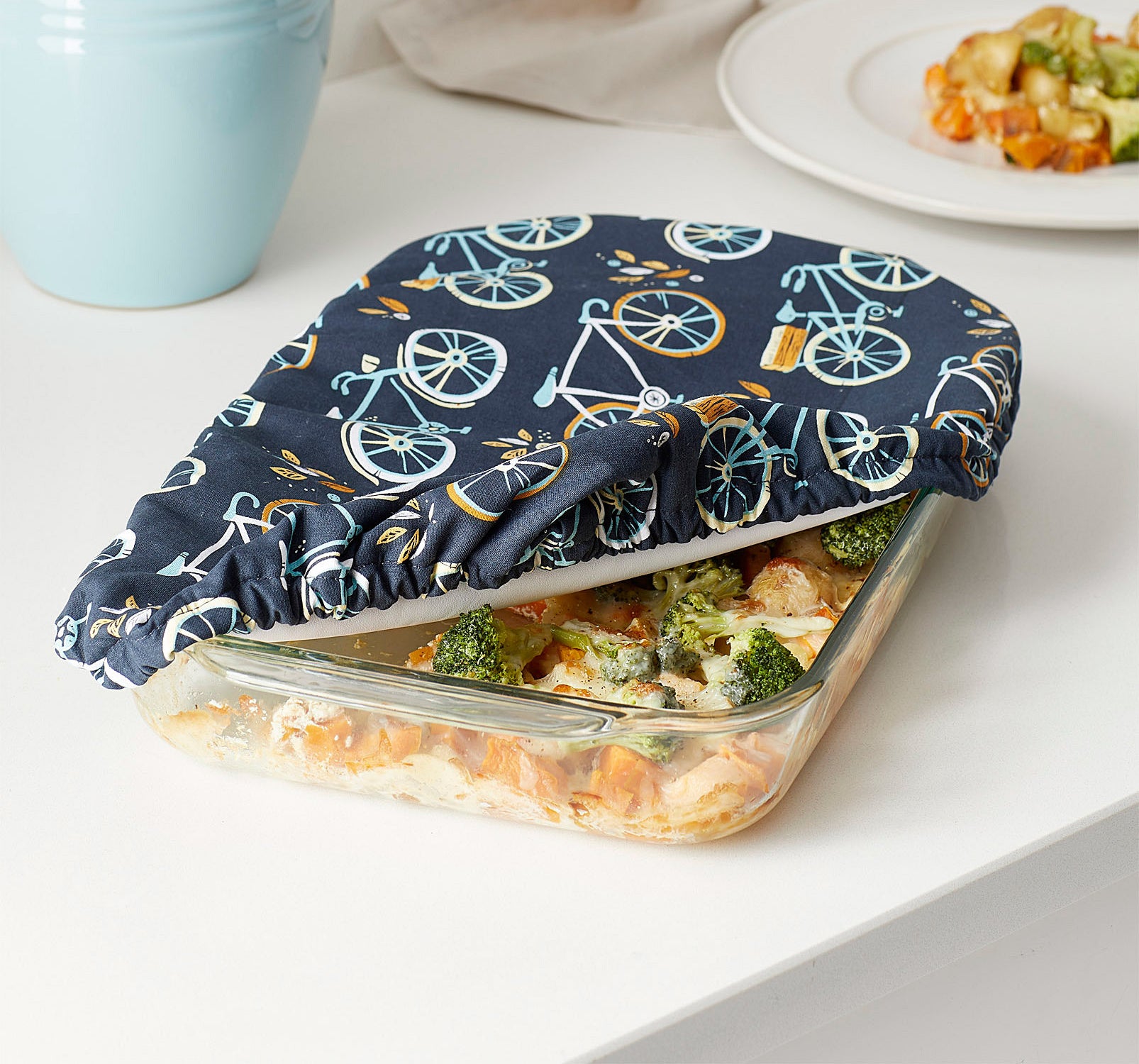 A glass dish pan with a fabric cover over it