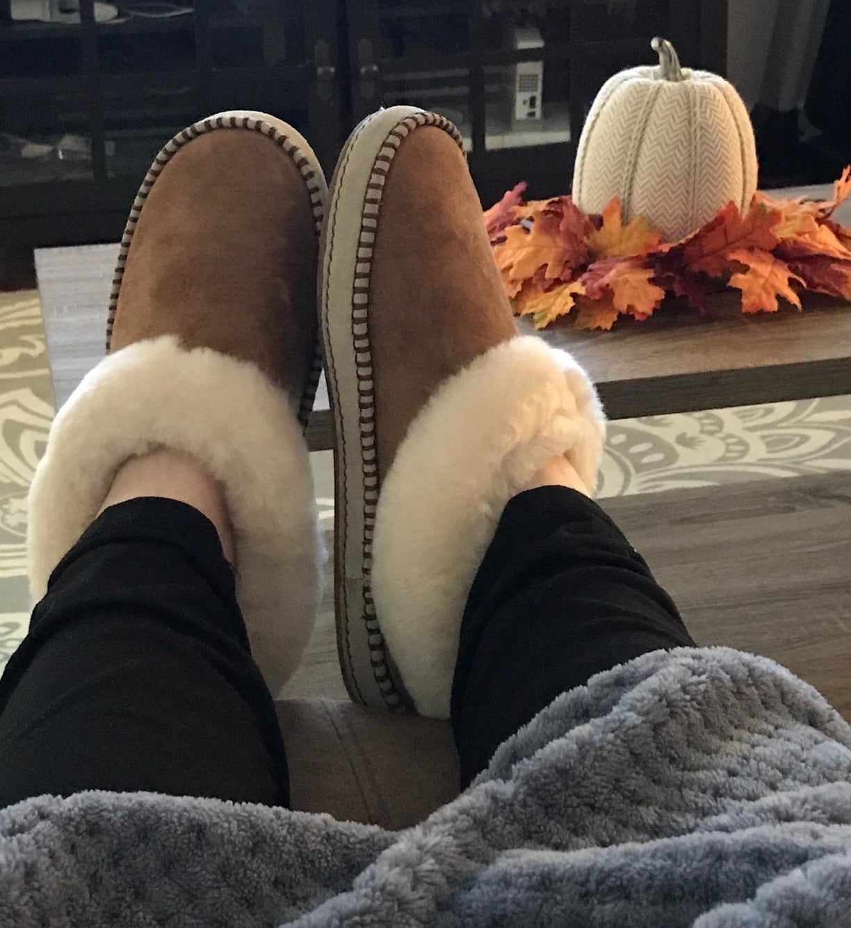 A reviewer wearing the slippers in chestnut