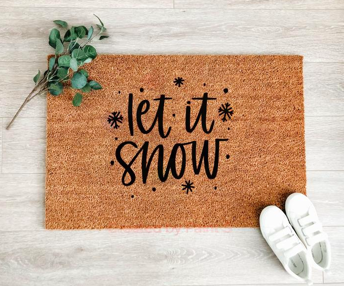 A coarse door mat that says let it snow