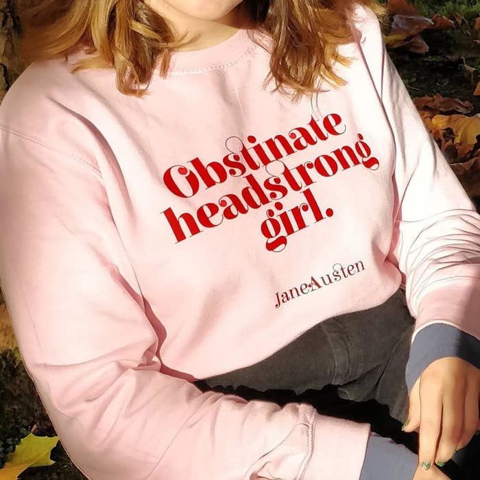 Model in the pink sweatshirt with red text