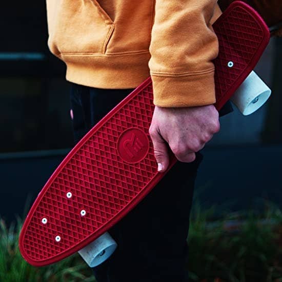 A person holding the skateboard against their leg