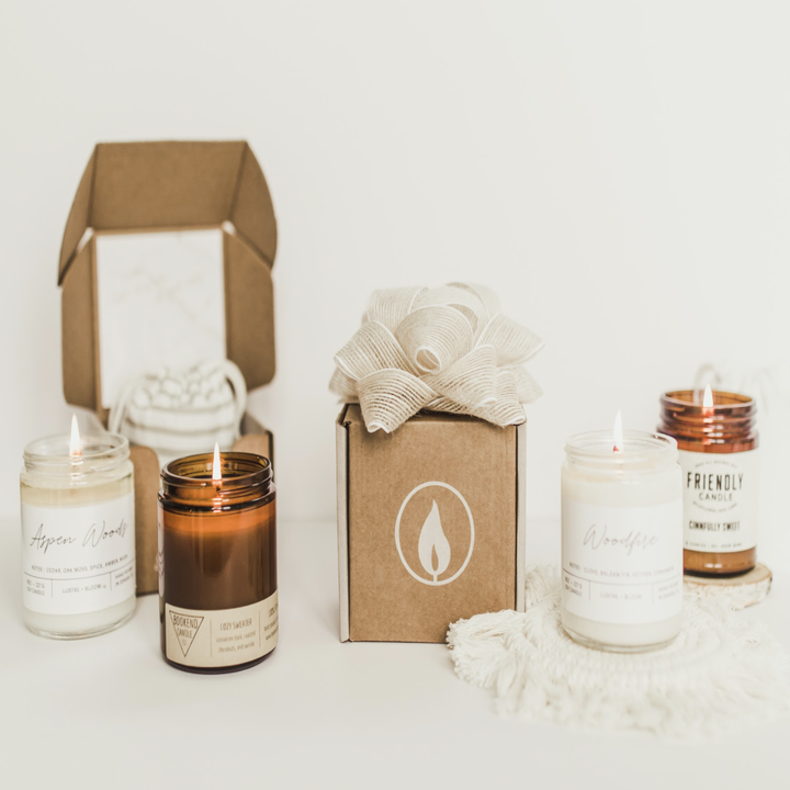 Vellabox subscription packaging and four candles in clear and amber jars